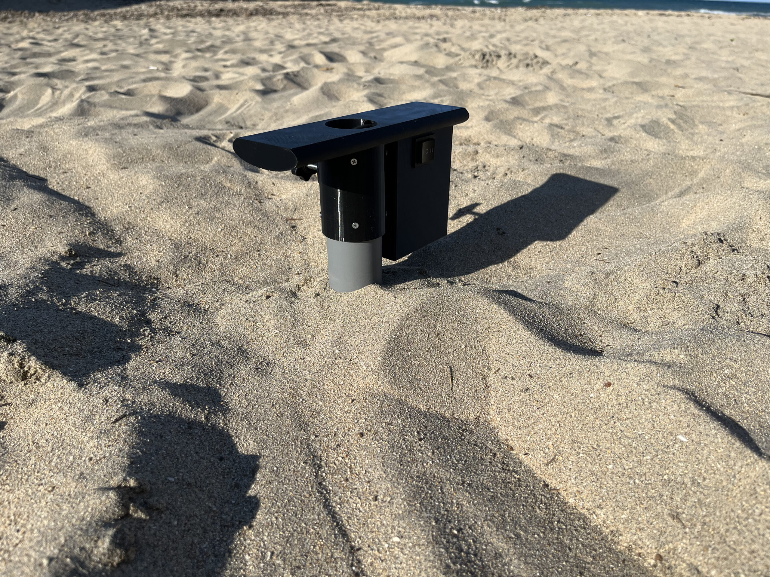 Installazione di un ombrellone con trivella elettrica sulla spiaggia